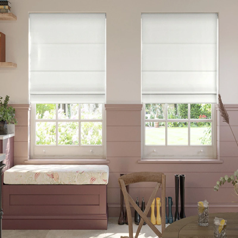 a dining area, two windows covered with white Roman shades, and a view of a garden outside