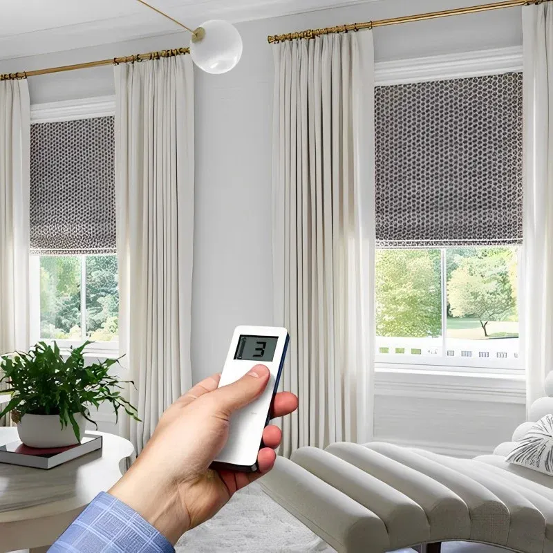 _Living room featuring a person adjusting automated window blinds with a remote.